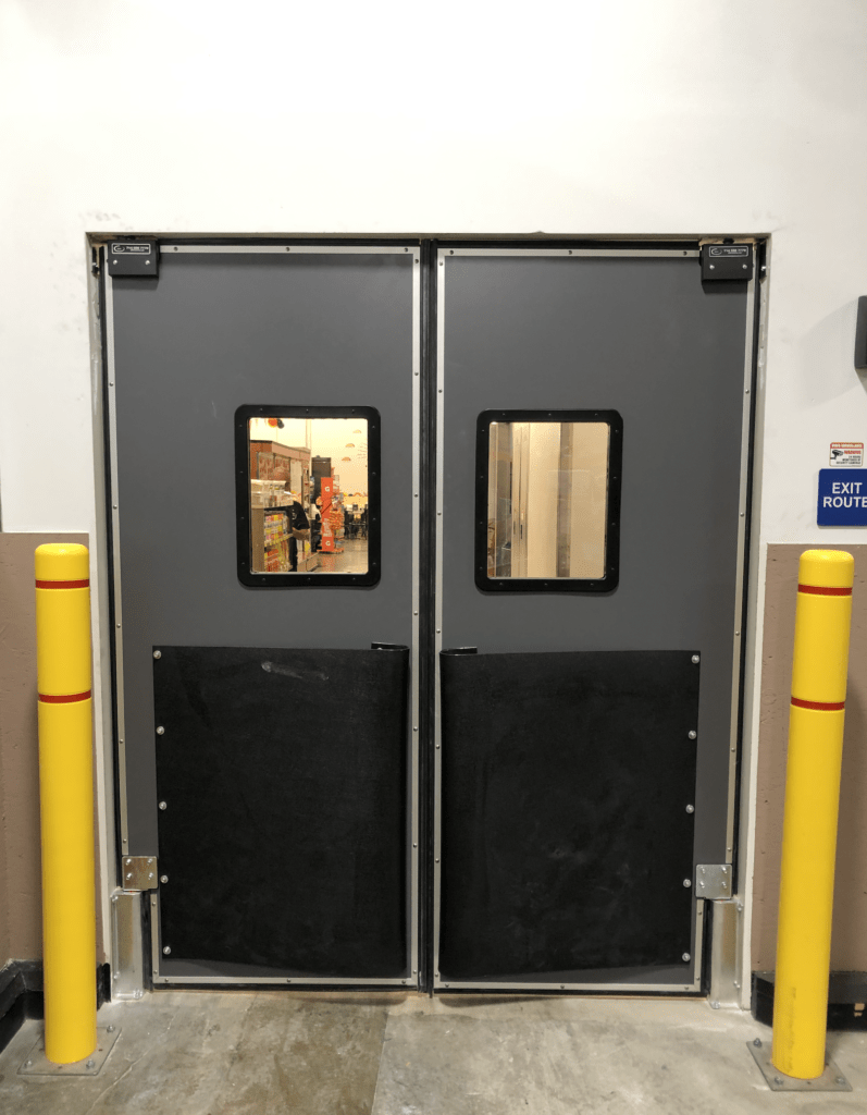 Double gray doors with small windows lead to a store's interior