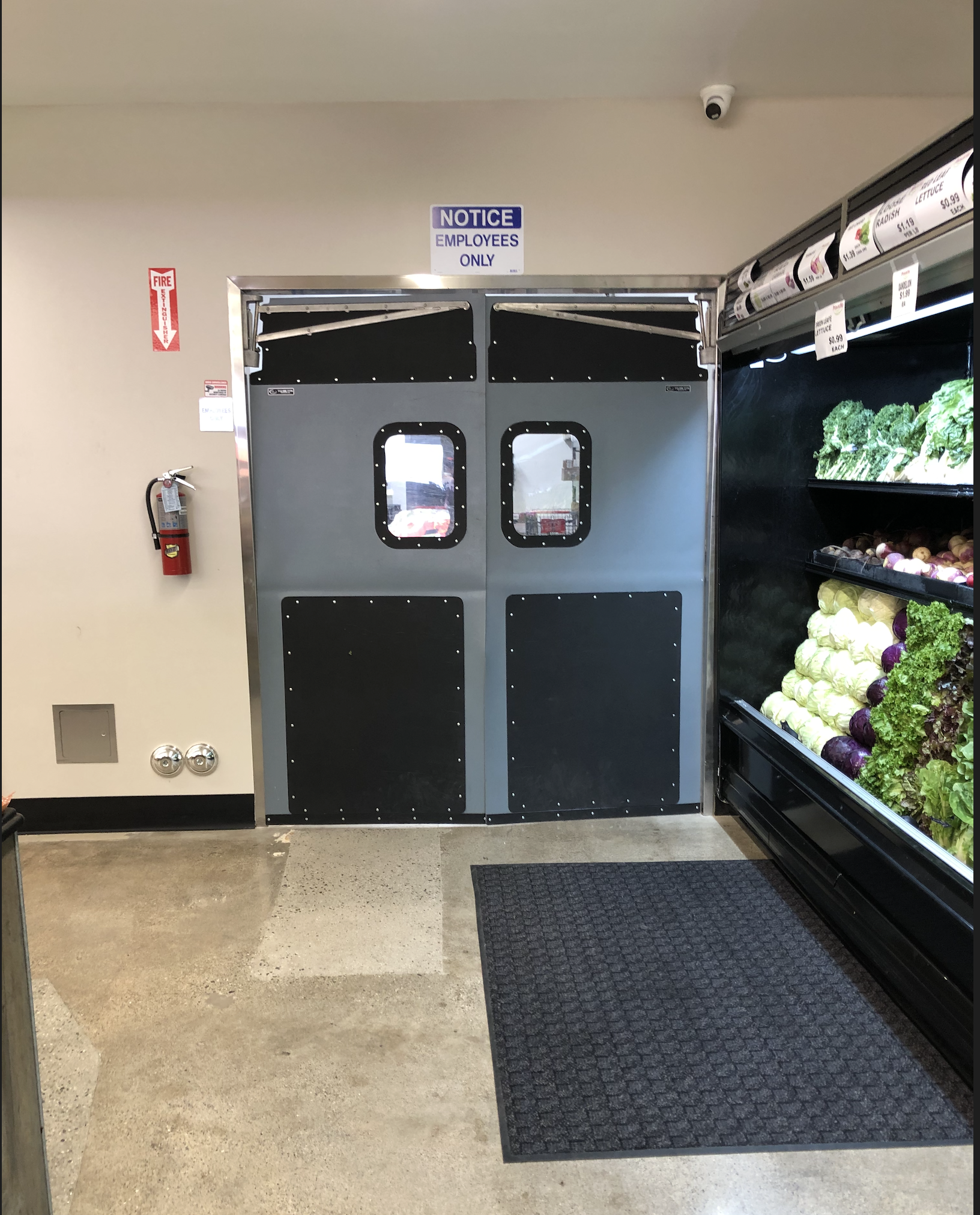 Dual doors labeled "Employees Only" lead to a restricted area in a grocery store